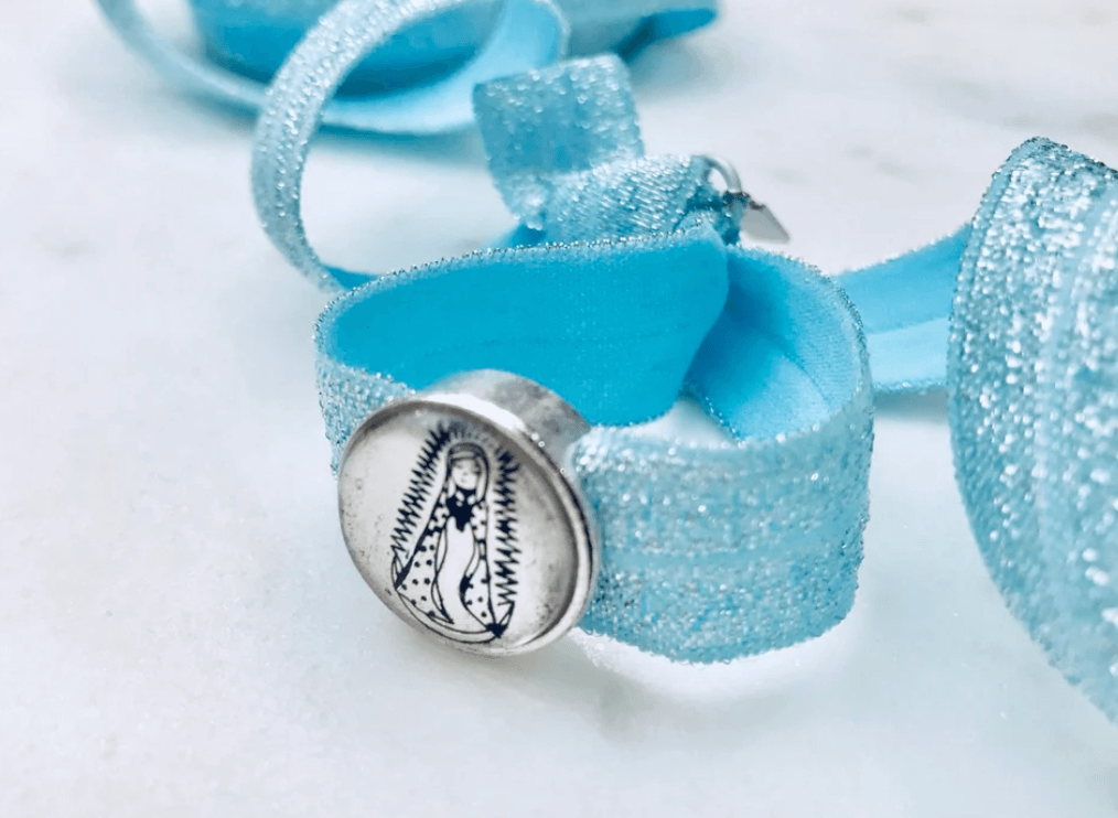 Sparkly blue fabric bracelet with Our Lady of Guadalupe medal in center