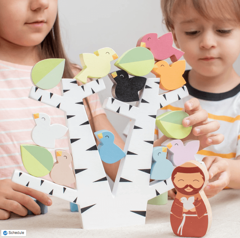 Two children playing with Saint Francis and the birds stacking toy.