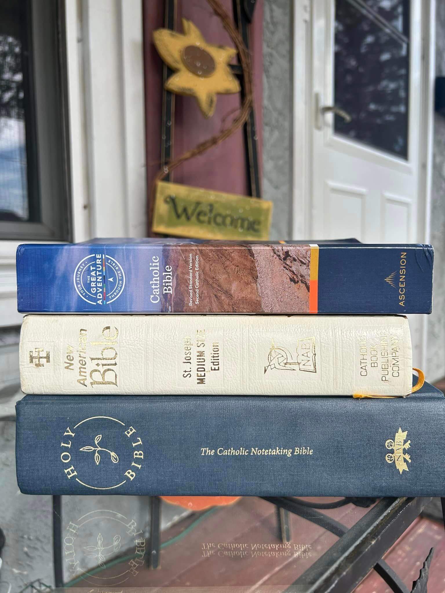 3 bibles stacked on an outside table