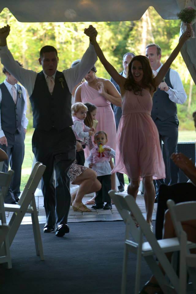 couple entered wedding reception with hands up in the air