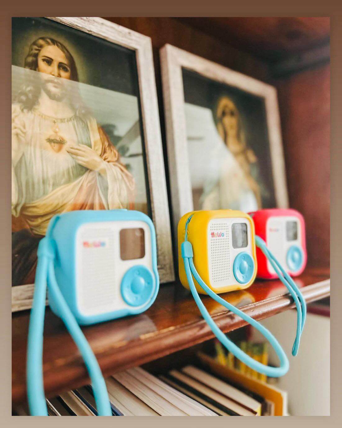 HeWo audio players, 3 of them in front of holy images of Jesus and Mary