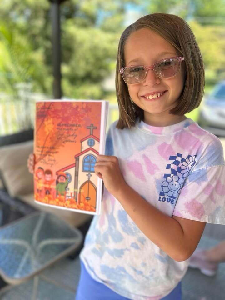 Young girl holding Catholic Magazine
